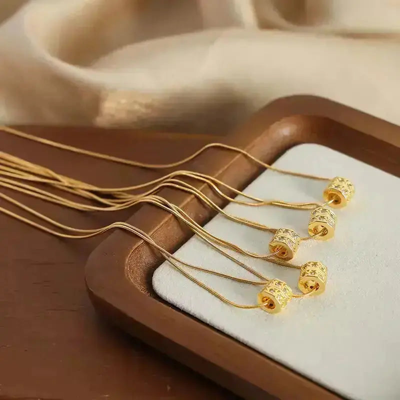 Gold stainless steel necklaces with floral bead pendants on a display tray