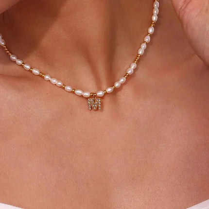 Close-up of a pearl and gold beaded necklace with crystal pendant on neck