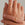 Gold ring with a diamond on a hand against a neutral background