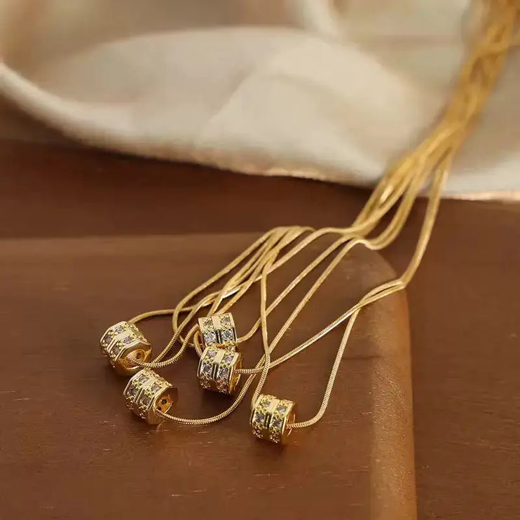 Gold necklace with diamond-like beads on a brown surface