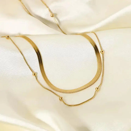 Gold necklace on a soft beige fabric background