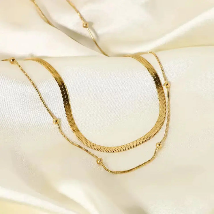 Gold necklace on a soft beige fabric background