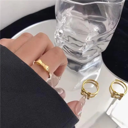 Gold ring on a finger with a glass of water in the background