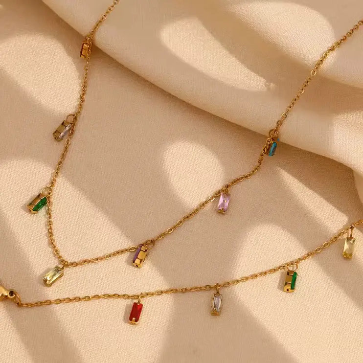 Necklace with colourful pendants worn by a person, with a blurred background