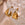 Organic-shaped gold stainless steel hoop earrings on a clear textured glass dish
