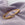 Gold twisted stainless steel bracelet with clasp on soft lavender fabric