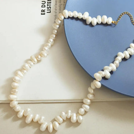 Pearl necklace on a blue heart-shaped object with a white background