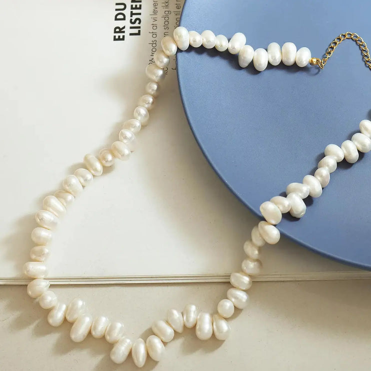 Pearl necklace on a blue heart-shaped object with a white background