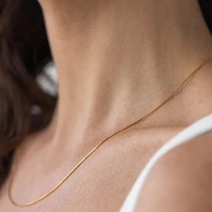 Close-up of a gold necklace on a person's neck