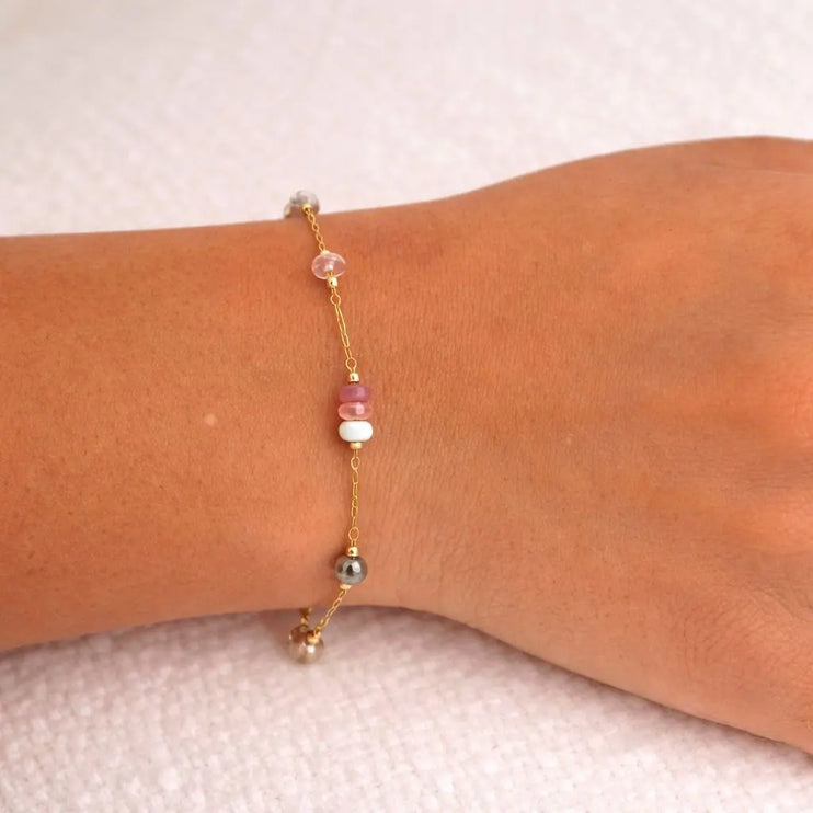 Bracelet with colorful beads on a wrist against a neutral background