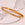 Textured gold stainless steel bracelet with embedded clear stones on a light background