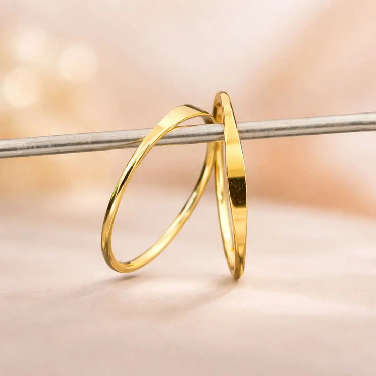 Two gold hoop earrings on a blurred background