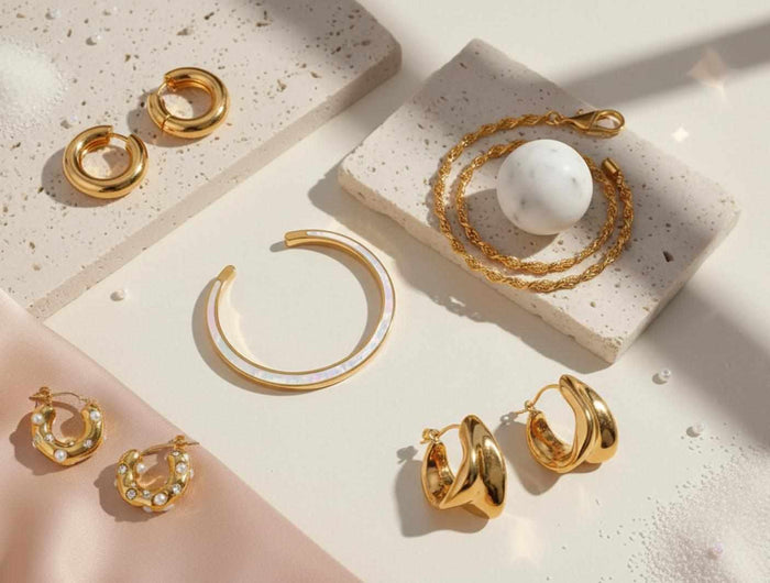 Gold hoop earrings displayed on a textured surface