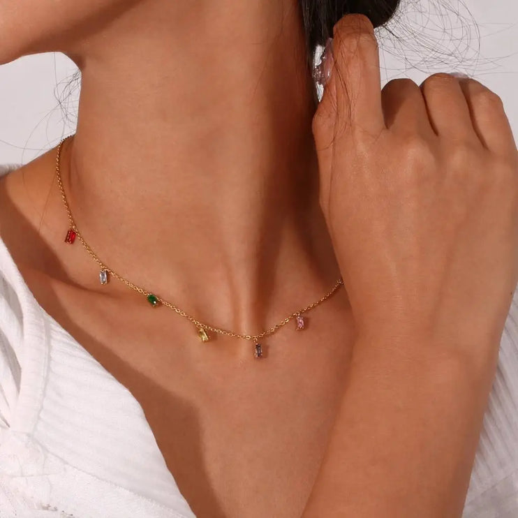 Necklace with colorful pendants worn by a person, with a blurred background