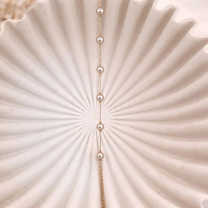 Pearl necklace on a textured beige surface