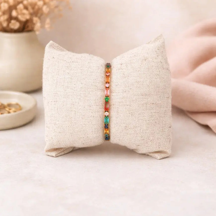 Bracelet with colorful beads on a textured pillow against a soft background