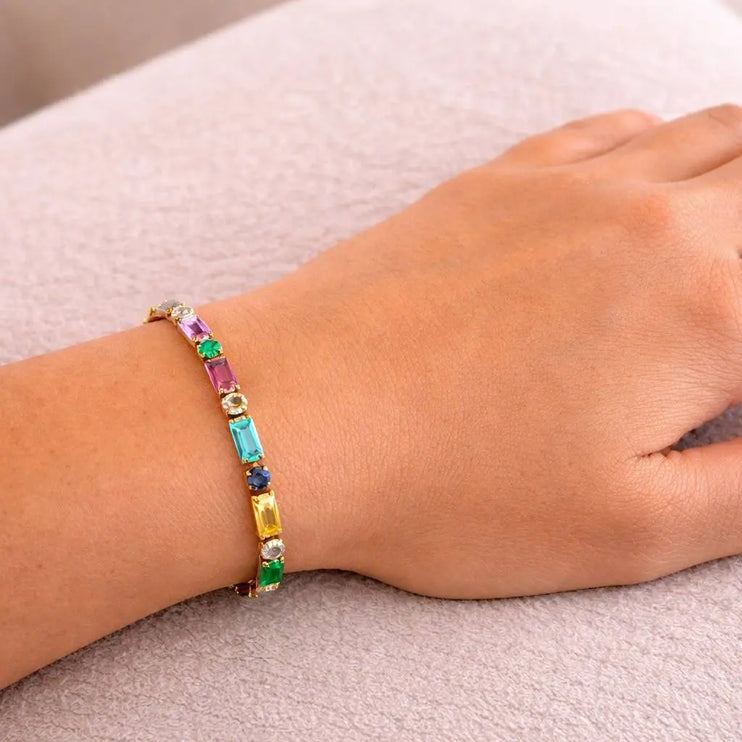 Multicolored beaded bracelet on a wrist against a neutral background