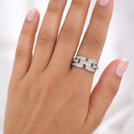Silver ring with diamonds on a hand against a white background