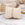Gold stainless steel bangle on linen pillow, marble surface, elegant minimalist jewelry display