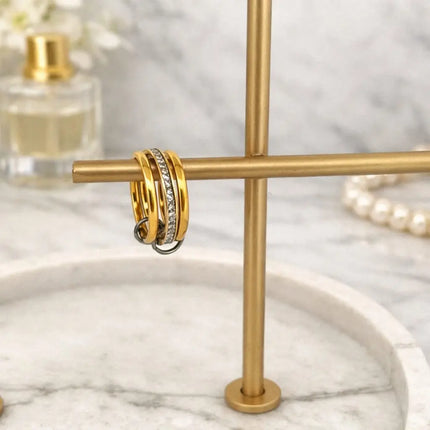 Gold hoop earrings on a gold stand with a marble background