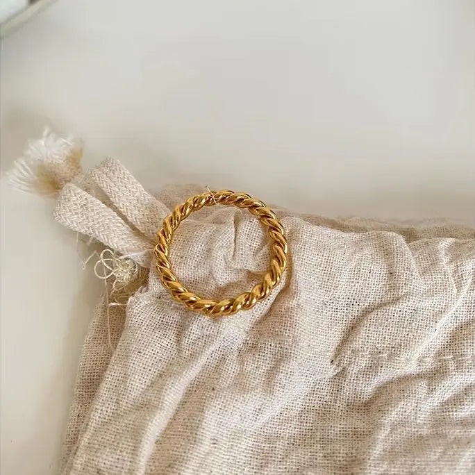 Gold ring on a textured beige fabric background