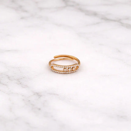 Gold ring with small stones on a marble surface