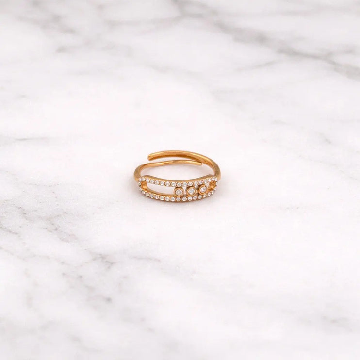 Gold ring with small stones on a marble surface