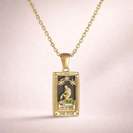 Gold pendant with tarot card design on a pink background